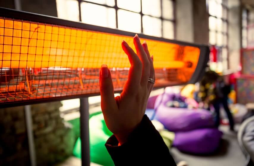 Woman-heating-hands-by-electric-heater.jpg